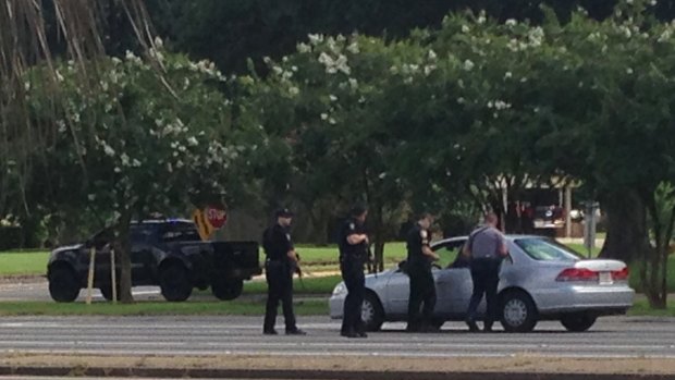 Authorities talk to the driver of a car near an area where several officers were shot in Baton Rouge on Sunday.