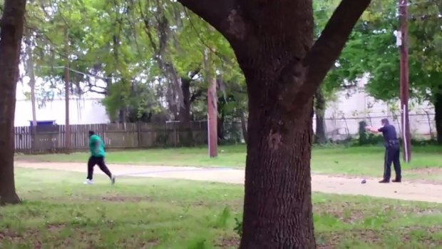 North Charleston police officer Michael Slager (right) points his gun at Walter Scott, 50, as he runs away.