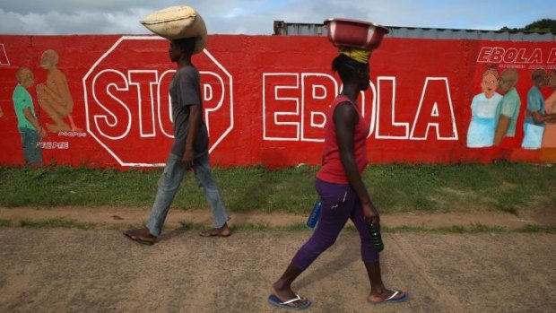 On alert: People pass an Ebola awareness mural in Monrovia, Liberia.