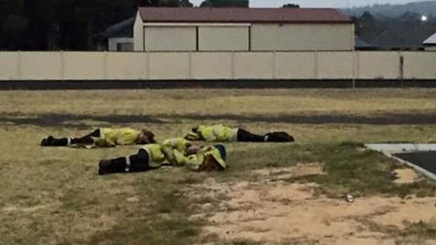 Exhausted firefighters kip on the lawn outside Harvey fire station. 