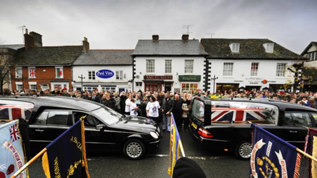 Mourners, friends and family line the road as coffins pass by during the funeral cortege of British soldiers in the streets of Wooton Bassett, Wiltshire. The bodies of six British servicemen killed in Afghanistan were flown home on Tuesday..