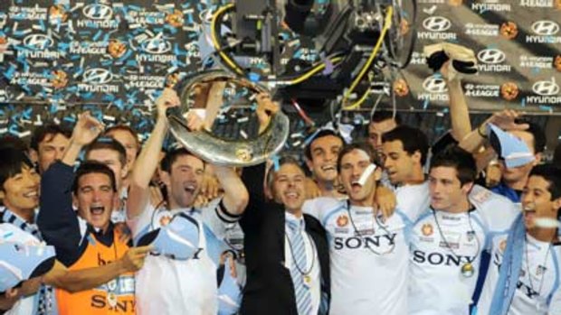 Time to party ... Sydney FC players, including injured skipper Steve Corica, hold aloft the A-League trophy for the second time after claiming the inaugural title