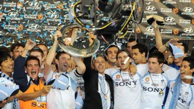 Time to party ... Sydney FC players, including injured skipper Steve Corica, hold aloft the A-League trophy for the second time after claiming the inaugural title