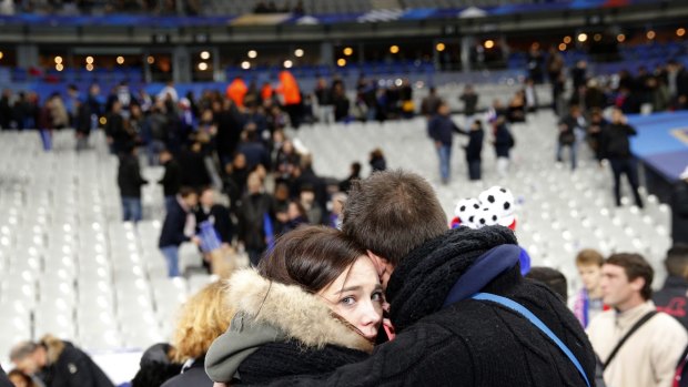 A supporter comforts a friend at the Stade de France.