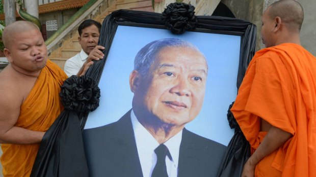 Mourning ... Buddhist monks carry a portrait of Norodom Sihanouk in preparation for the return of his body to Phnom Penh.