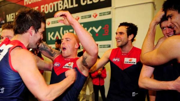 Jared Rivers (left) and Nathan Jones celebrate after the Demons' 73-point victory over the Swans at the MCG yesterday.