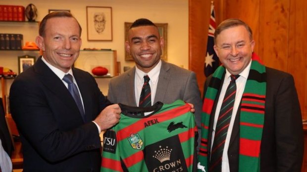 Prime Minister Tony Abbott is presented with a South Sydney jersey by Nathan Merritt and Labor MP Anthony Albanese.