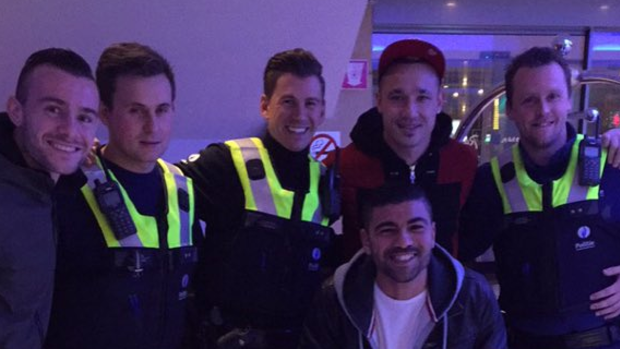 Happy ending: Radja Nainggolan poses with police officers who had been sent to investigate him. 