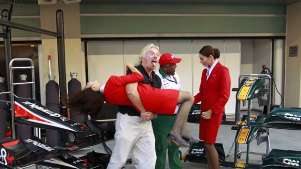 Richard Branson was measured for an AirAsia stewardess' outfit after losing his bet with Lotus Racing's team owner Tony Fernandes.