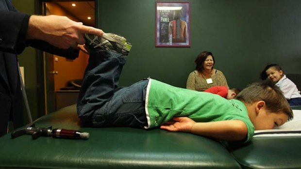 Putting the naughty bone back in: Riley Meares, age 4, during a routine back examination by his local chiropractor.