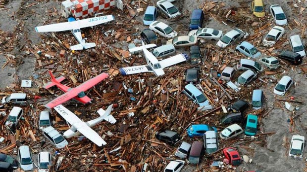 Cars and airplanes are left destroyed by the tsunami.