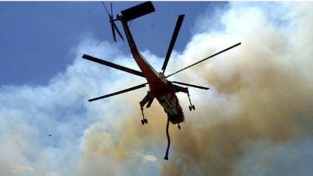 A helicopter water bombs the Endeavour Hills blaze.
