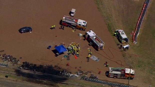 Emergency services crews work around the wreckage at Queensland Raceway.