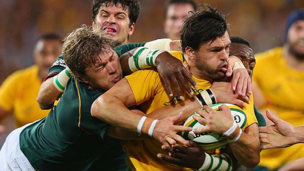 Heavy weather: Wallaby Adam Ashley-Cooper is tackled hard by the Springboks.