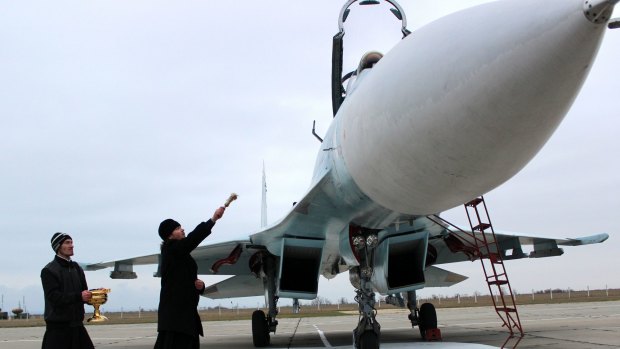 A Russian orthodox priest blesses a SU-27 SM fighter jet on the airfield of Belbek military airport outside Sevastopol, Crimea. Russia has moved 10 Russian SU-27 SM and four SU-30 fighter jets there. 