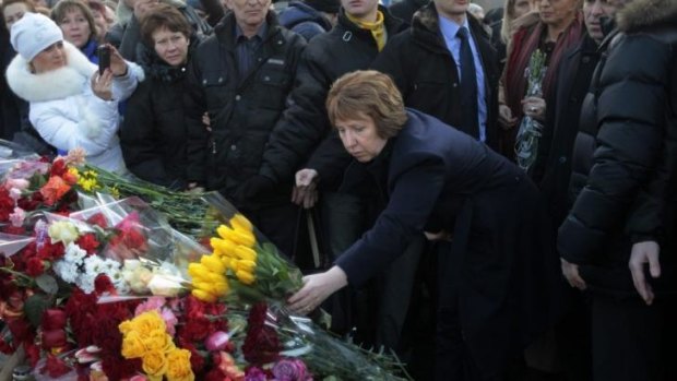 New white knight: EU foreign policy chief Catherine Ashton places flowers at a memorial for the people killed in clashes with the police in central Kiev, Ukraine.