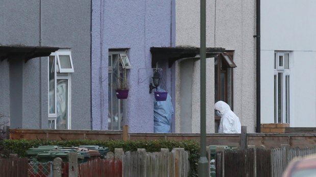 Forensic officers enter the home in southwest London for clues, following the arrest on an 18-year-old man on Saturday.