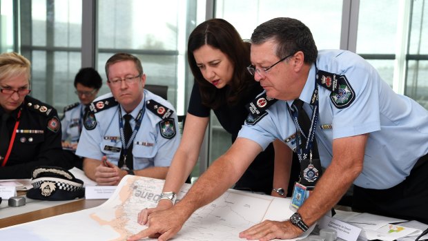 Queensland Premier Annastacia Palaszczuk (centre) is briefed by Police Commissioner Ian Stewart (right) on the floods situation in the state's north in March 2018.