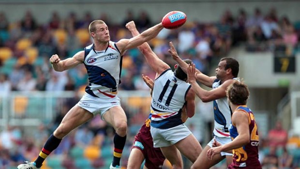 As the Crow flies: Scott Thompson, one of Adelaide's heroes in the win over Brisbane, punches the ball clear of a pack.