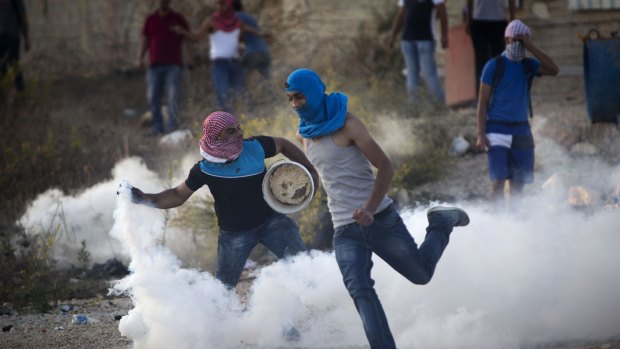 A Palestinian protester throws back a tear gas canister that was fired by Israeli troops during clashes near Ramallah, West Bank, in October. US ambassador Daniel Shapiro has criticised  Palestinians attacks on Israelis.