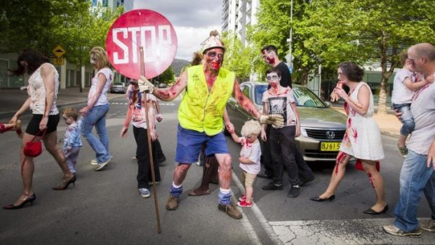  Dead stop: Paul McKie of Downer stops traffic for his fellow zombies in Civic during the annual Canberra Zombie Walk.
