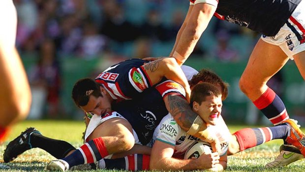 Lachlan Coote of the Panthers is brought down by the Roosters defence.