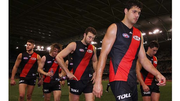 Essendon players leave the field after a belting from Hawthorn.
