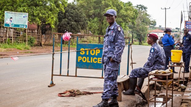 Police guard a roadblock as the Sierra Leone government enforces a three-day lockdown on movement of all people.