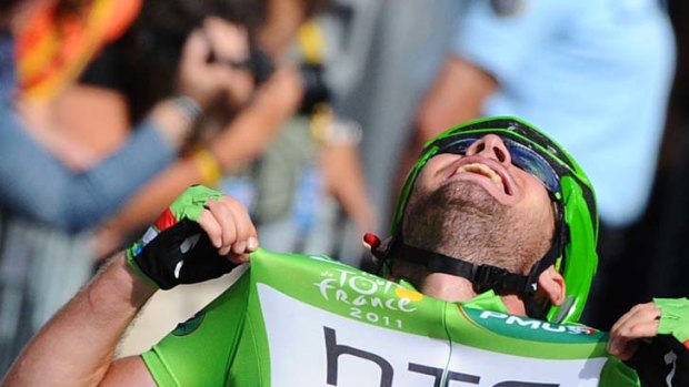 Mark Cavendish celebrates on the finish line after winning his third successive stage on the famous Champs-Elysees.