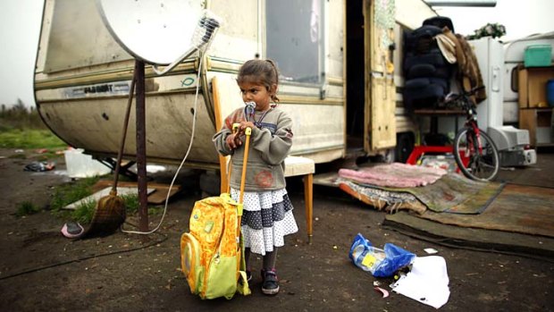 Fringes of society: A Roma girl plays outside her family's caravan at an encampment of Roma families near Paris.