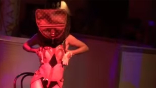 A striptease performer, wearing a bag on her head, emerges from a birthday cake at M&C Saatchi's 21st birthday party.