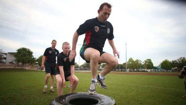 Tony Abbott, pictured during an exercise session with troops last year, has a new buddy.