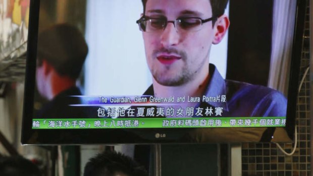 A TV screen shows a news report on Edward Snowden, a former CIA employee who leaked top-secret documents about sweeping US surveillance programs, at a restaurant in Hong Kong Wednesday, June 12, 2013.