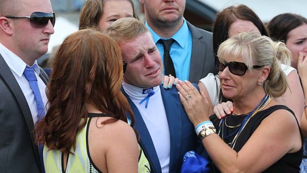 Tommy, comforted by friends and family during the minute's silence.