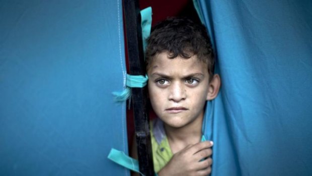 Childhood lost: a displaced Palestinian boy looks out from a makeshift tent at the al-Shifa Hospital in Gaza City.
