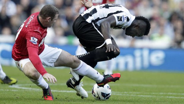 Cheick Tiote of Newcastle United tangles with Wayne Rooney.