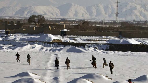 Afghans run for cover in the snow during clashes with police.