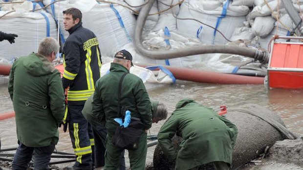 Firefighters and police look at a 1.8 ton WWII bomb in the Rhine river.
