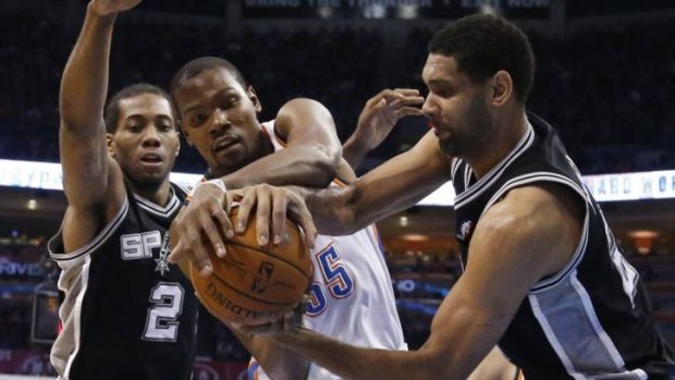 Oklahoma City Thunder forward Kevin Durant and San Antonio counterpart Tim Duncan vie for control of the ball in front of Spurs forward Kawhi Leonard in Oklahoma City.