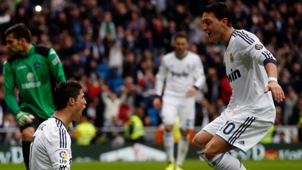 Cristiano Ronaldo (left) celebrates a goal with teammate Mesut Ozil.