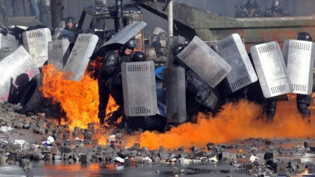 Riot police shield themselves during clashes with protesters in central Kiev.