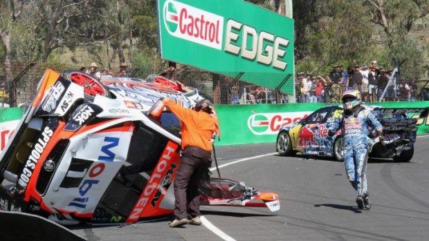 Craig Lowndes rushes to aid Warren Luff after their crash during practice at the Bathurst 1000.
