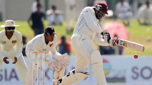 Chris Gayle  is watched by Sri Lankan wicketkeeper Prasanna Jayawardene as he advances to drive.