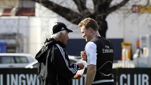 Magpies coach Mick Malthouse (left) shares a lolly from his lolly bag with assistant coach Nathan Buckley during a Collingwood training session, 2010.