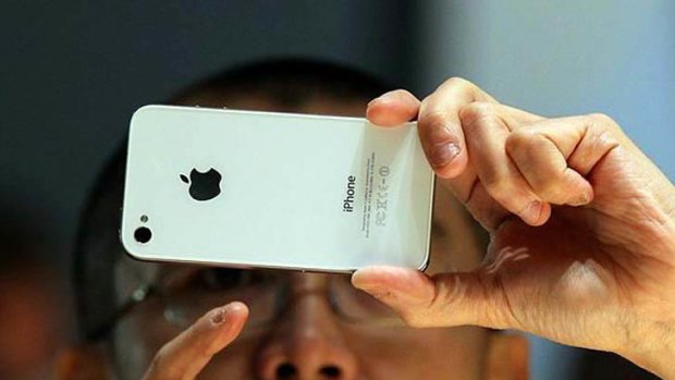 A visitor inspects an Apple iPhone 4 at the Apple Worldwide Developers conference in San Francisco in June.