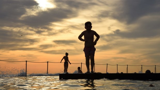 A young boy prepares to dive into the water at Bronte Baths a rock pool at Bronte Beach in the early morning before the temperature soars to 37 degrees. Bronte, Sydney. 