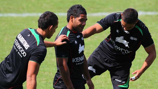 The go-to man . . . halfback Chris Sandow offers a set of steady shoulders for his stretching teammates during a South Sydney training session at Redfern Oval yesterday.