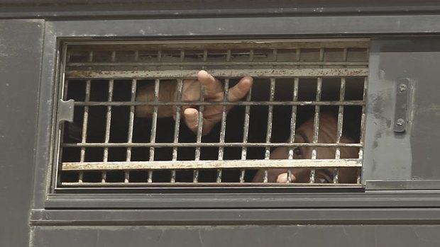 A Palestinian prisoner waves from the window of a bus as it leaves Nafha Prison, Mitzpe Ramon.
