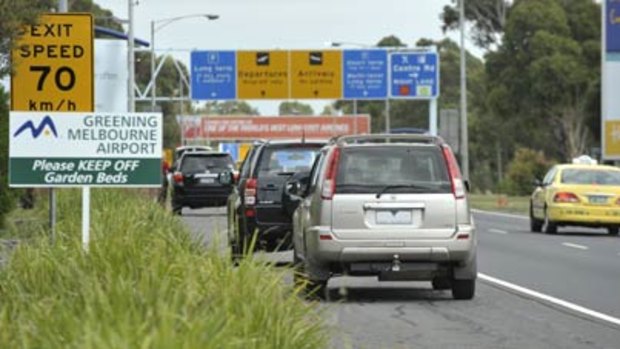 Cars park on the side of the road to avoid airport parking.