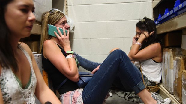 Women make phone calls while taking shelter during the shooting.